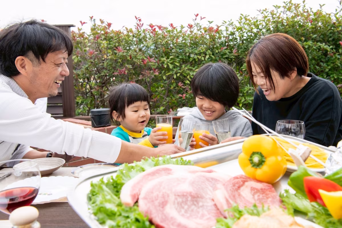テラスでバーベキューをしている家族の写真